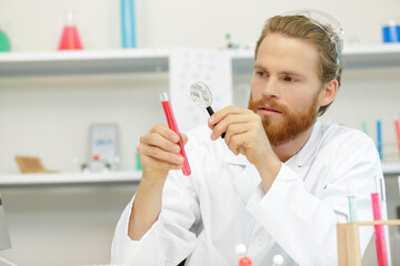 man using a magnifying glass pipette