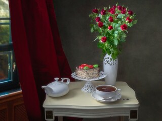 Still life with a bouquet of spray roses and a piece of cake