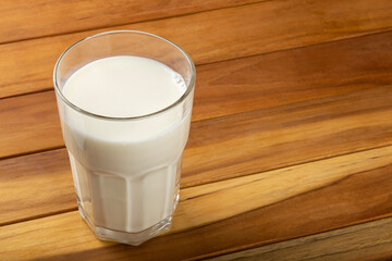 Glass of milk on the wooden table.