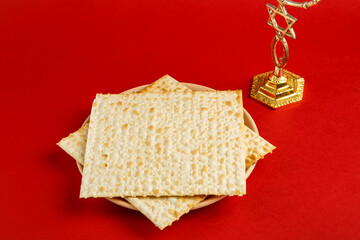 Matzah in the shape of a star of david on a red background and a glass of wine for kiddush m menorah.