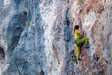 A strong woman climbs a rock, Rock climbing in Turkey.