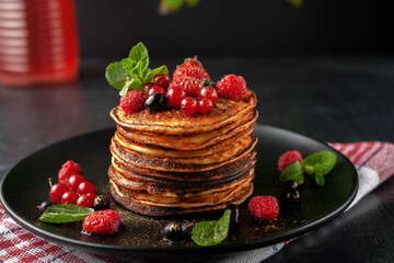 Delicious, only baked pancakes with fresh fruits of raspberries, currants and strawberries