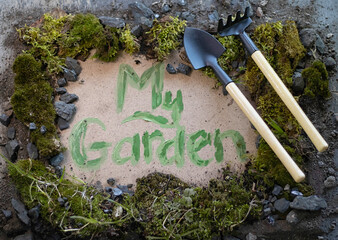 The inscription my garden on a wooden background with herbs and stones. Decorative board with text...