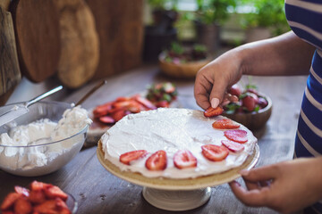 Women preparing strawberry cake