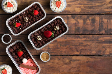 Strawberry cakes with chocolate on a wooden table. Space for text