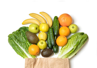 Top view of paper bag with fresh vegetables and fruits, isolated on white background.