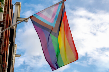 Celebration of pride month in Amsterdam, New rainbow flag hanging outside the building, Symbol of Gay, Lesbian, Bisexual and Transgender, LGBT community in Holland, Social movements, Netherlands.