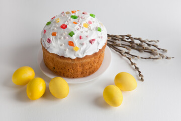 Easter cake and yellow Easter eggs with willow branches on a white background