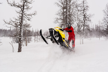 Mountain snowmobile riders ride on the slopes