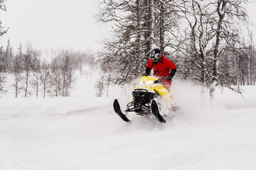 Mountain snowmobile riders ride on the slopes