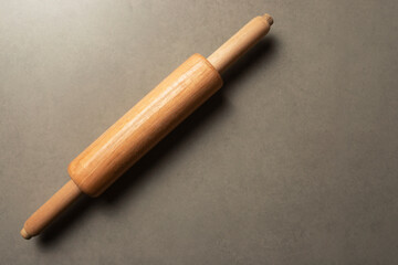 Rolling pin on a gray surface. Top view. Space for text.