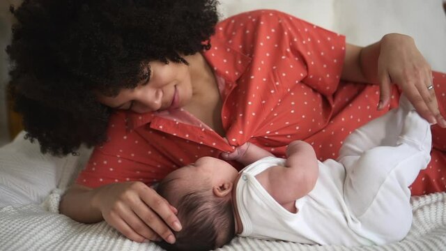 Mom having good time with cute baby and lying on bed in home bedroom spbd.