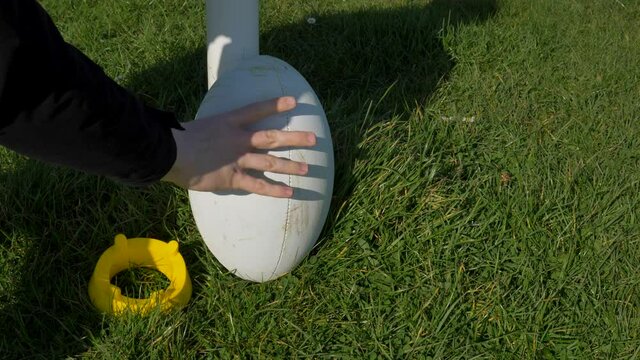 Close Up Shot of Rugby Ball and Tee Being Placed Next to Rugby Post