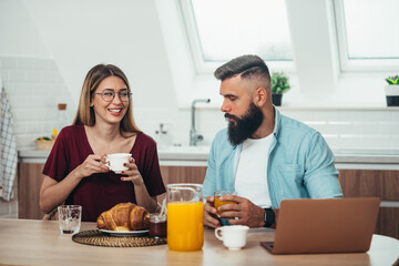 Couple having breakfast in the kitchen at home