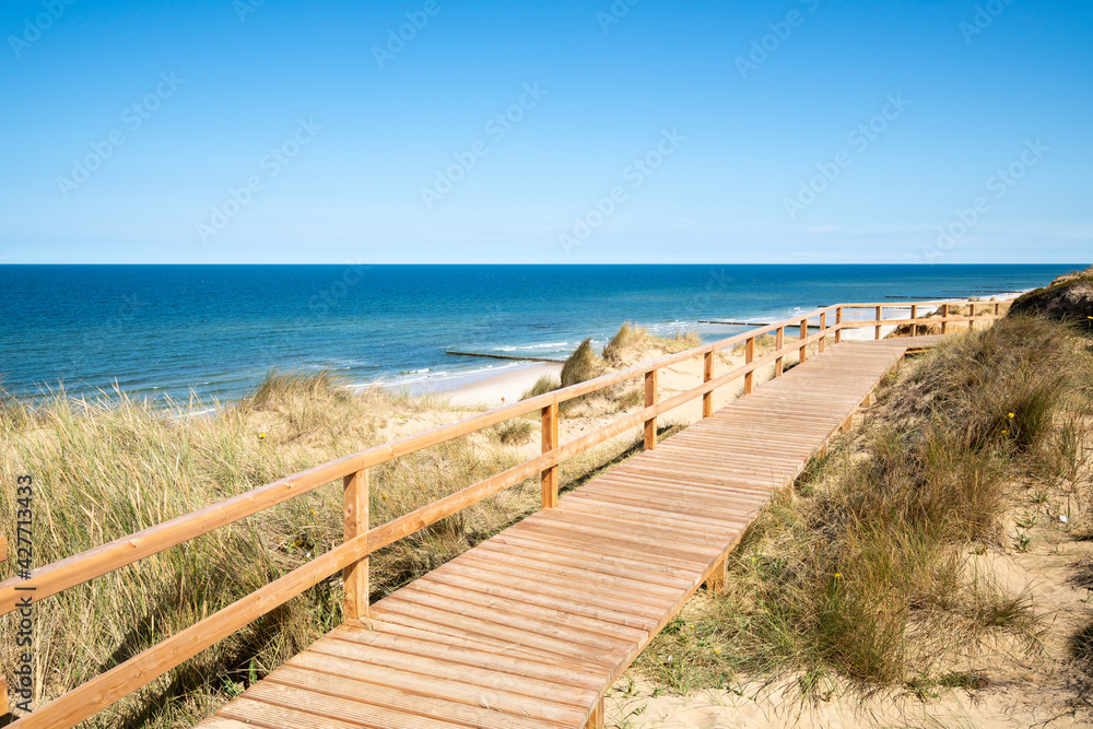 Wall mural wooden boardwalk along the rotes kliff (red cliff) on the island of sylt, schleswig-holstein, german