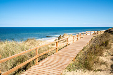 Wooden boardwalk along the Rotes Kliff (red cliff) on the island of Sylt, Schleswig-Holstein, Germany - obrazy, fototapety, plakaty