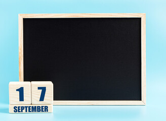 September 17. Day 17 of month, Cube calendar with date, empty frame on light blue background. Place for your text. Autumn month, day of the year concept