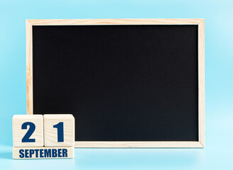 September 21. Day 21 of month, Cube calendar with date, empty frame on light blue background. Place for your text. Autumn month, day of the year concept