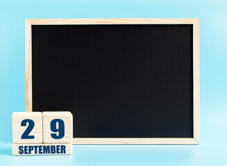 September 29. Day 29 of month, Cube calendar with date, empty frame on light blue background. Place for your text. Autumn month, day of the year concept