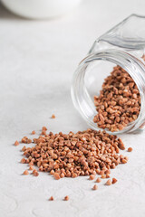 Raw buckwheat grains are scattered on the table. Healthy eating.