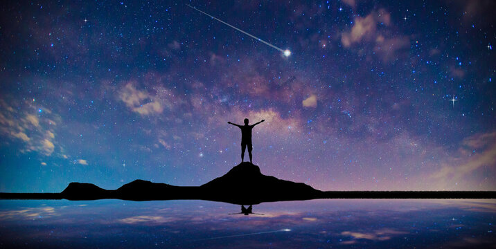 meteor or shooting star .Traveler Man Silhouette Stand Top Mountain. blur background. victory success business.