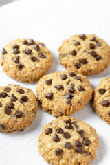 Delicious Whole Wheat Chocolate Chip Cookies set on white cafe table.