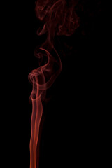 Abstract orange smoke swirling on a black background.