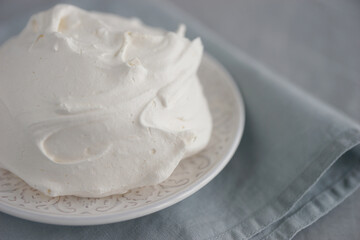 Large meringue on a plate and a blue napkin