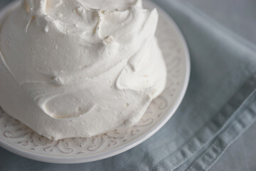 Large meringue on a plate and a blue napkin