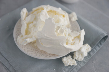 Large meringue on a plate and a blue napkin