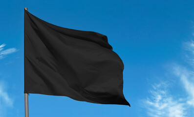 Blank fabric black flag, mourning flag against blue sky