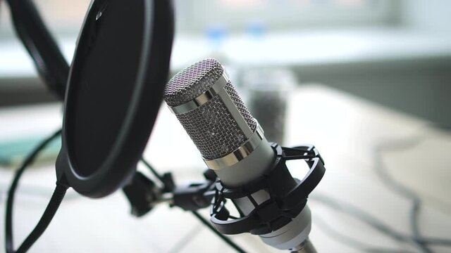 Closeup view of microphone standing on table in radio studio during broadcast spbd.