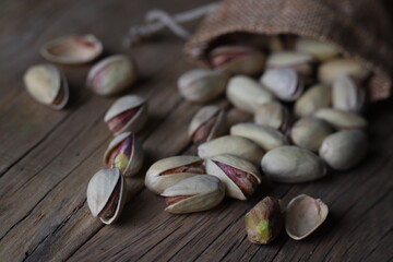 delicious pistachios in a shell on a textured wooden table