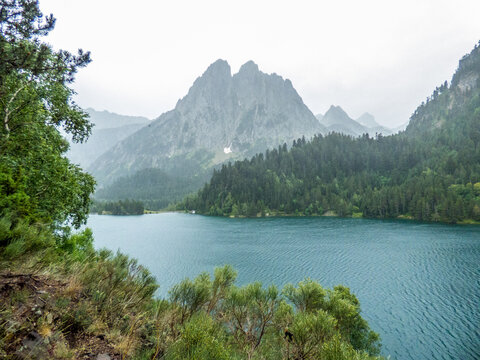 Dos picos gemelos, conocidos como Els Encantats (los encantados) junto al lago de San Mauricio y rodeado de bosques de pino negro en el Parque Nacional de Aig&uuml;es Tortes, Espa&ntilde;a