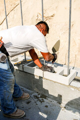 Mason laying cinder block retaining wall
