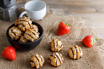 Homemade vegan coconut cookies dipped in chocolate. Served in bowl with strawberry's on the side.