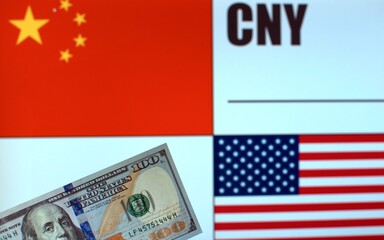 100 US dollars banknote on blurred background of Chinese and American flags and currency code of China. Exchange rate template