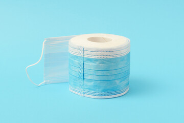 The creative concept of a pandemic. A roll of toilet paper with medical masks.