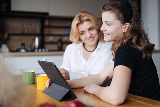 Mother Discussing With Her Daughter Teenager While Drinking Tea In Living Room At Home