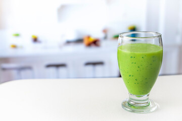 very healthy green juice on white table in kitchen