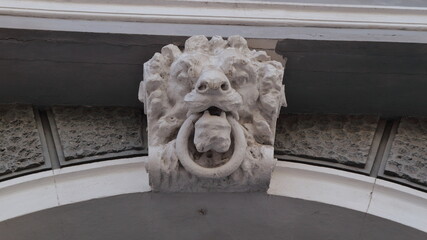 An architectural element in the form of a lion's head with a ring in its teeth on one of the old buildings in Odessa.