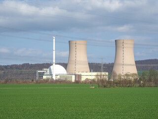 nuclear power plant against sky and green grass