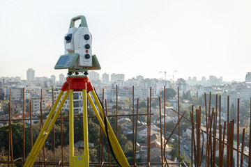 device for geodesy measurement on a construction site against a background of a gray wall