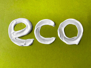 Concept of zero waste, natural cosmetics.ECO cream lettering. White letters on green craft eco background. Flat lay.
