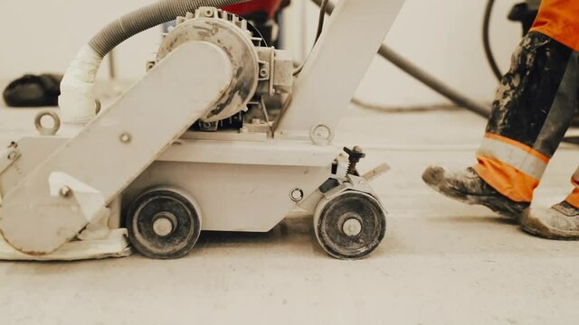 Workers grind the concrete floor at the construction site.