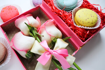 set of macaroons in a gift box and a bouquet of flowers 