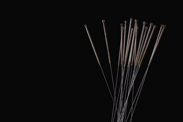 Silver needles for traditional Chinese medicine acupuncture. Close-up. Isolated on black background.
