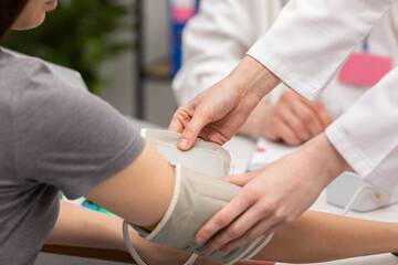 Close-up view of a nurse placing a blood pressure monitor on a patient's arm. General practitioner. Doctor's office