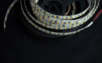 Reel with LED strip for voltage of 12 volts on a black background.