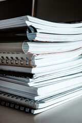 Stack of reports lies on a desk ready for review